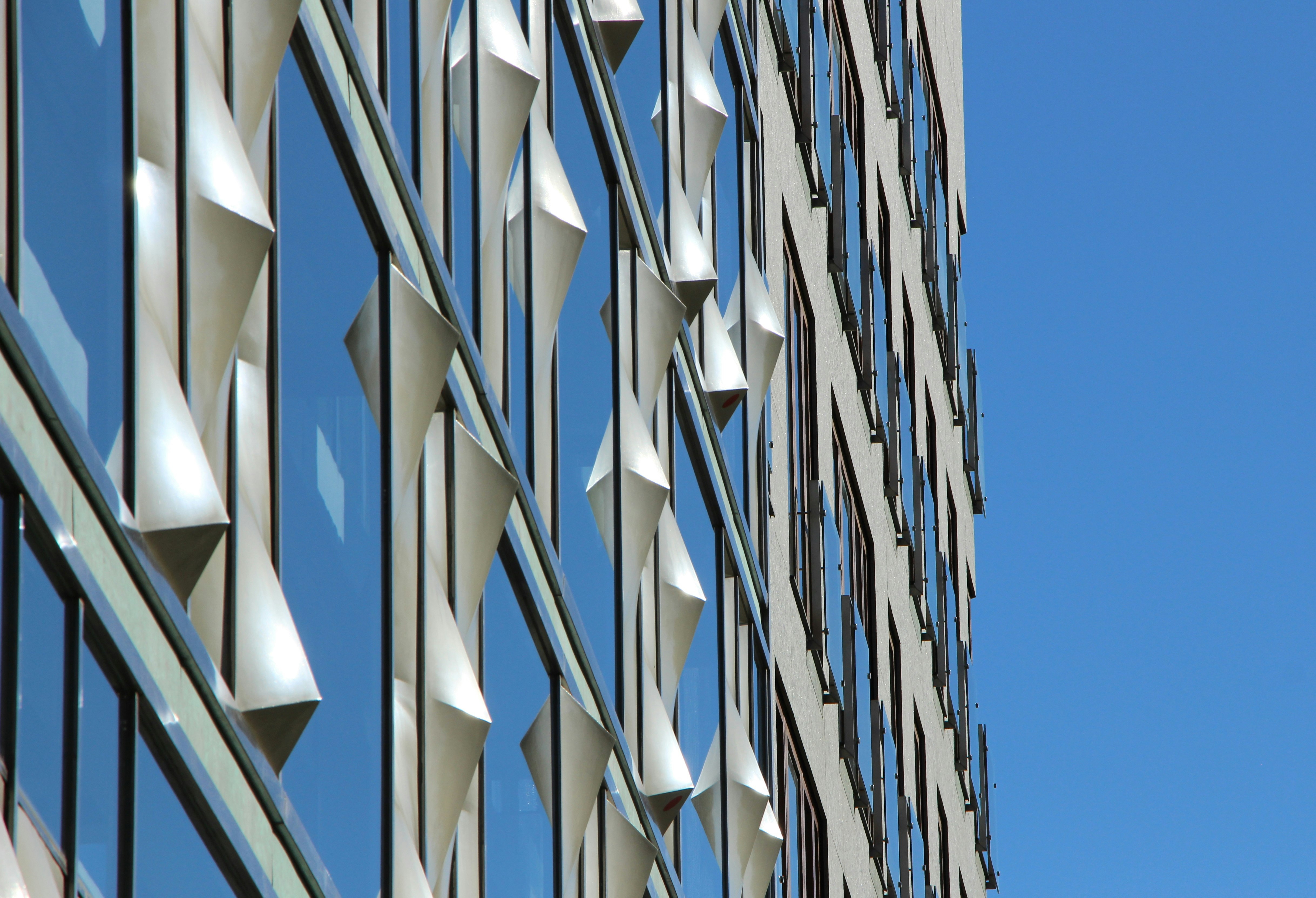 low-angle photography of curtain wall building under blue sky at daytime